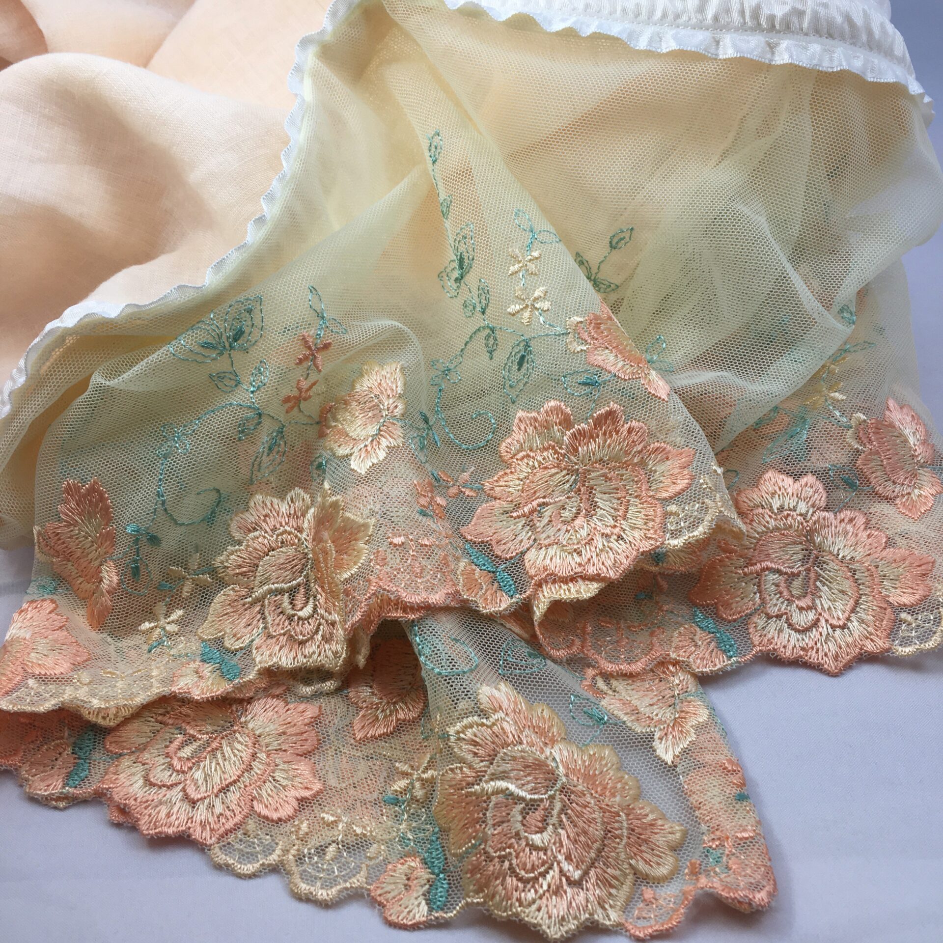 Hand-made shawl in peach. linen and lavishly embroidered peach and blue-green lace