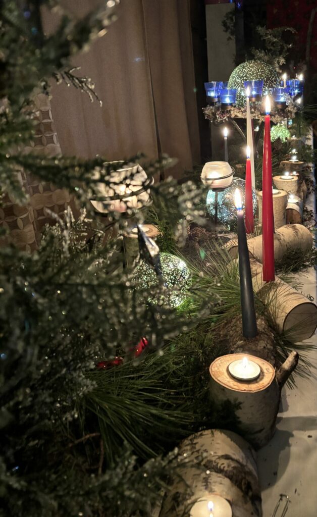 Winter Solstice altar of evergreens, white birch logs, and assorted candles